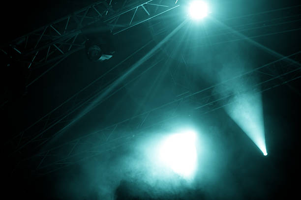 A view of foggy stage lights emerging from the dark stock photo