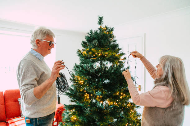 istock Happy senior couple decorating Christmas tree together 1849396804