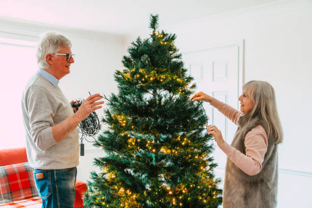 istock Happy senior couple decorating Christmas tree together 1849396808
