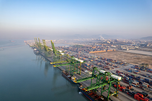 An aerial view of an international container freight port in the early morning