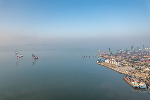 An aerial view of an international container freight port in the early morning