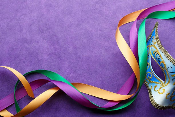 A Mardi Gras mask and colorful ribbon on a purple background.