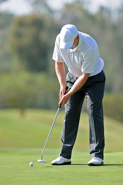 istock Young male golfer putting on the green 184940202