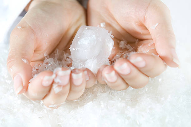Woman's hands holding ice cubes stock photo