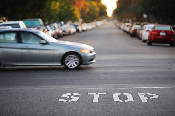 road junction, stop parola, movimento offuscata auto - safety yellow road striped foto e immagini stock