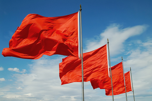 Four flags flutter in the breeze on a sunny day: the flag of Great Britain, the flag of Europe, the flag of Switzerland and the flag of the United States.