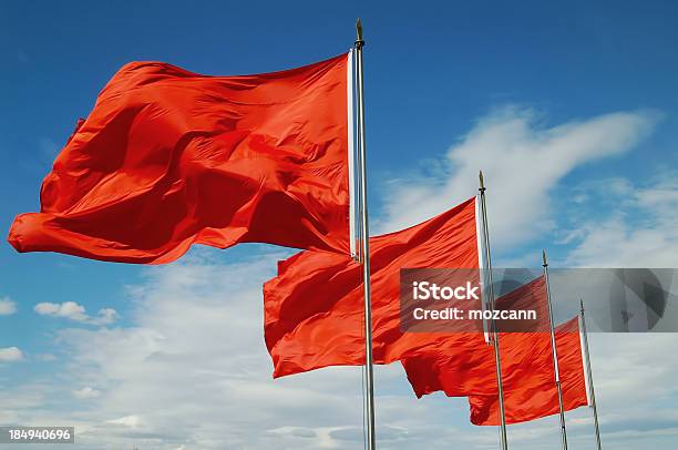 A Row Of Red Flags Blowing In The Wind Stock Photo - Download Image Now - Flag, Red, Wind