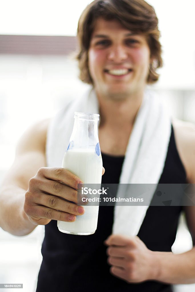 Atletica uomo sorridente con Bottiglia del latte - Foto stock royalty-free di 25-29 anni