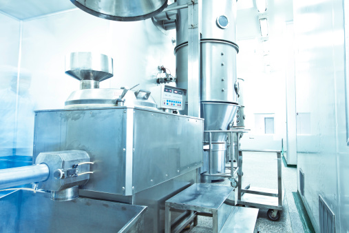 pharmaceutical factory equipment working with unrecognizable technician in blue