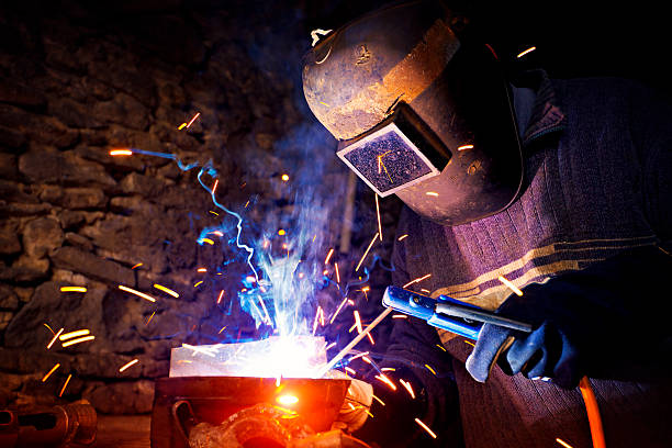 Welder at work Welder at work welding helmet stock pictures, royalty-free photos & images