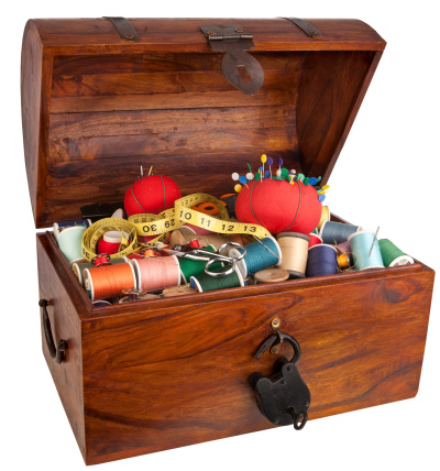 a treasure chest filled with colorful spools of thread and various other sewing items