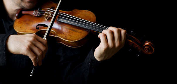 Violin and music sheets on wooden table, top view