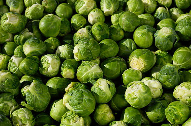Organic brussel sprouts vegetables on display in wooden boxes at a street food market fair festival