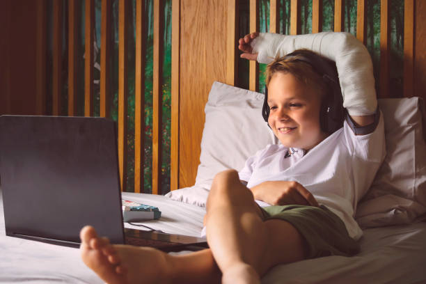 istock happy boy looking at laptop on bed 1849430357