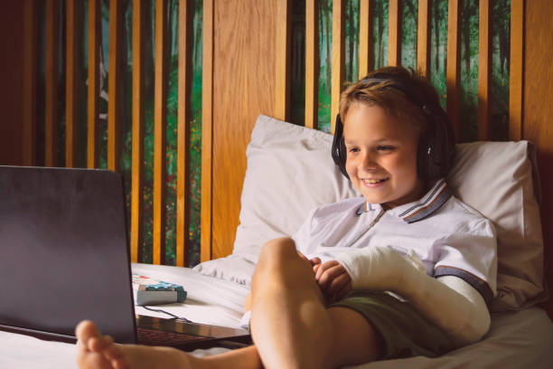istock happy boy looking at laptop on bed 1849430364