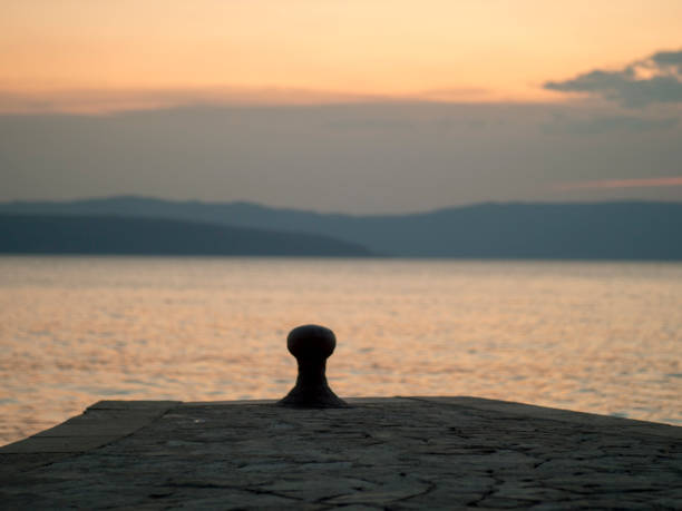 istock Pier at sunset with island in background 1849434086