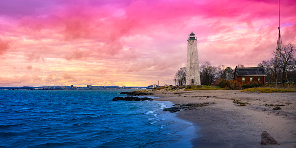 New Haven Landmark Lighthouse at the beachfront of Morgan Point Park, built in 1847 in Connecticut. Winter coastal landscape in New England at dramatic cloudy sunset in America.