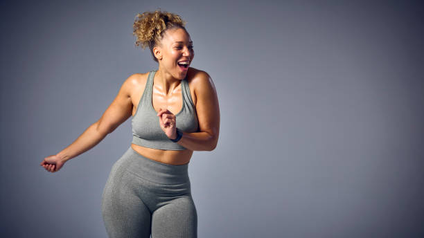 Studio Shot Of Woman Wearing Gym Fitness Clothing Dancing In Zumba Class On Grey Background Studio Shot Of Woman Wearing Gym Fitness Clothing Dancing In Zumba Class On Grey Background zumba image stock pictures, royalty-free photos & images