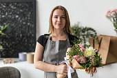 An employee of a flower boutique holds a freshly picked bouquet