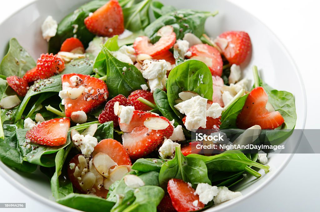 Green salad with strawberries and spinach SEVERAL MORE IN THIS SERIES. Fresh salad of baby spinach leaves, sliced strawberries, slivered almonds, feta cheese, and a light dressing. Shallow DOF. Salad Stock Photo