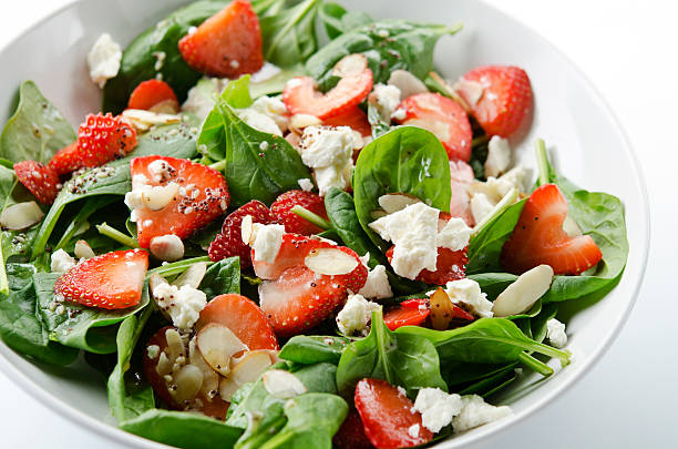 Green salad with strawberries and spinach SEVERAL MORE IN THIS SERIES. Fresh salad of baby spinach leaves, sliced strawberries, slivered almonds, feta cheese, and a light dressing. Shallow DOF. spinach photos stock pictures, royalty-free photos & images