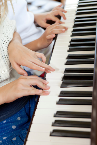 Sisters practicing on the piano.Click to see more of this Family.