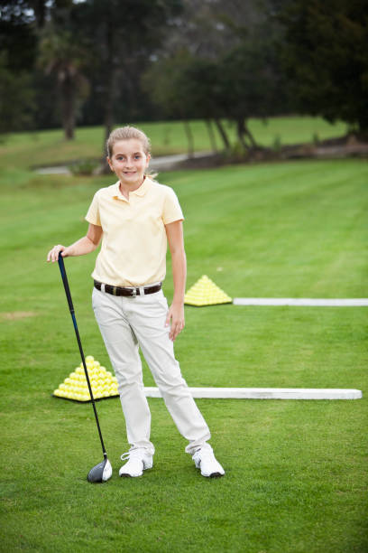 niña de pie en un campo de práctica de golf - sc0529 fotografías e imágenes de stock