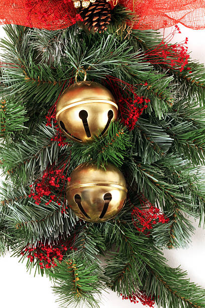 Pine branch greenery, red mini flowers, two brass bells.