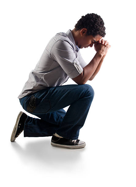 istock Teenager praying on his knees 184944834