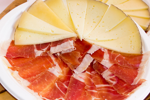 Slices of cured ham  and cheese, decorated circle plate, typical \