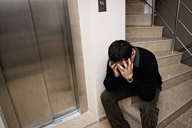 istock sad man sitting on stairs 184945598