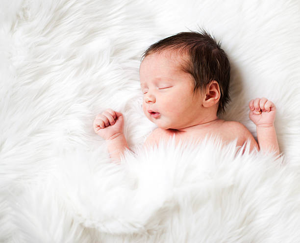 istock Newborn Baby Sleeping on White Fur Rug 184945810