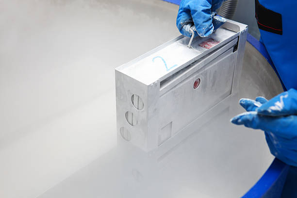 contenitore con il liquido nitrogen.doctor con tuta hazmat al lavoro - cryobiology foto e immagini stock