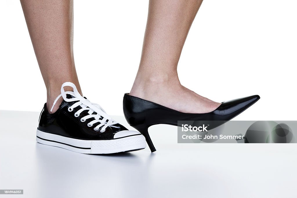 Mujer usando un zapato de vestir y sneaker - Foto de stock de Vestirse formal libre de derechos