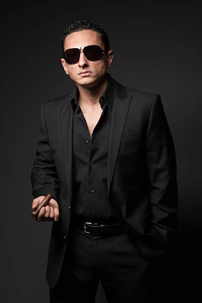 istock Businessman in black suit with a cigar 184946057