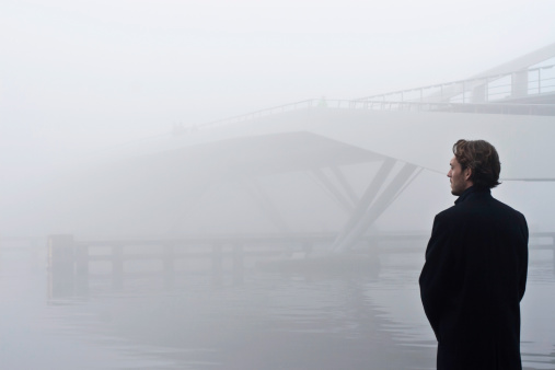 man looking at a bridge in the fogsimilar images: