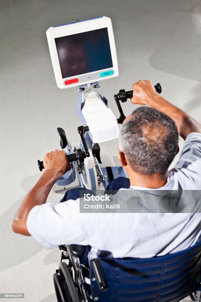 Uomo anziano utilizzando attrezzature per esercizi di terapia fisica - Foto stock royalty-free di 60-64 anni