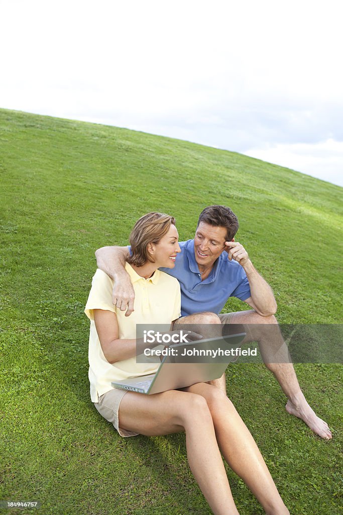 Mature couple having fun At sunset looking at computer Adult Stock Photo