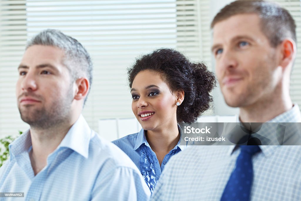 Businesswoman on seminar Three business people during business conference. Focus on smiling businesswoman sitting in second row. 25-29 Years Stock Photo