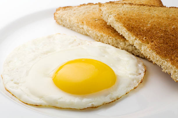 Fried egg sunny side up and plain sliced toast stock photo