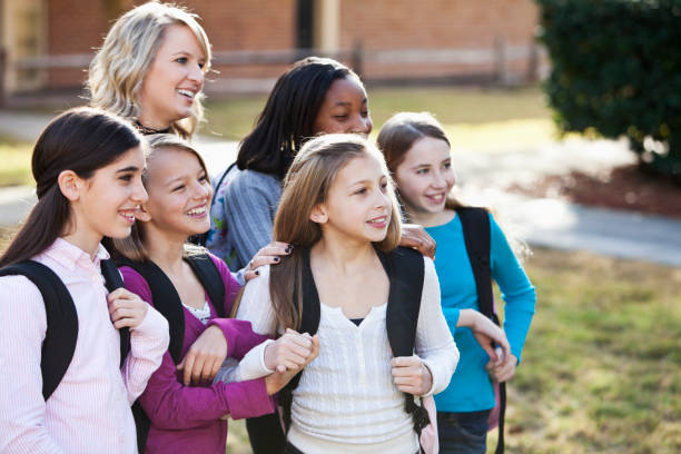 istock Teacher and students standing outside school 184947245