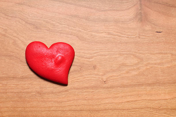 Heart made of dough on wooden table