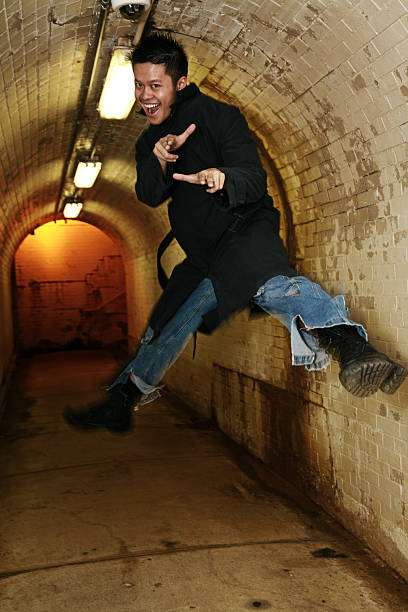 Action Jump Shot young asian man (twenty) jumping in a tunnel - motion blur on legs modelkt stock pictures, royalty-free photos & images