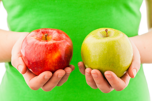 Woman comparing green and red  apple