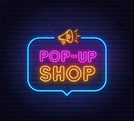 Pop Up Shop neon sign in the speech bubble on brick wall background