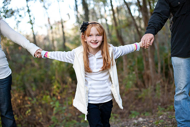 istock Girl is holding her parents hands 184948106