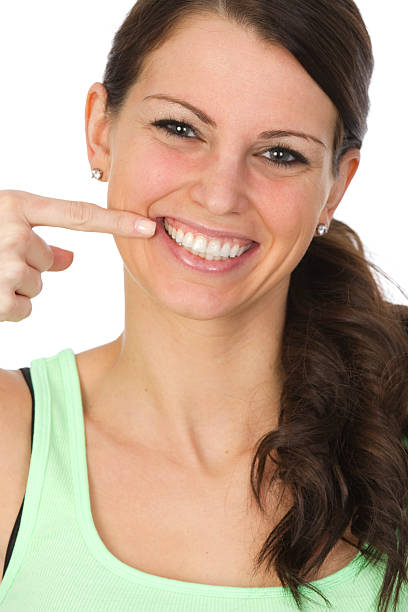 istock smiling woman pointing at her teeth 184948760