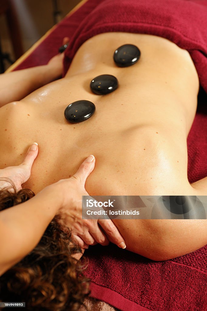 Caucasiano adulto tendo uma terapia com pedras quentes A massagem - Foto de stock de Alívio royalty-free