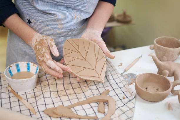 istock woman forming leaf shaped clay by hands, closeup in artistic studio 1849508055