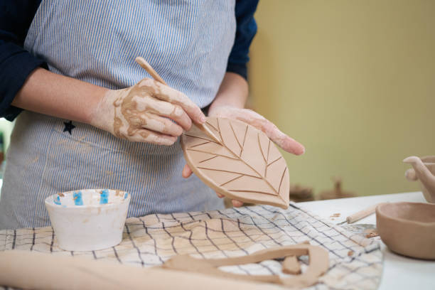 istock woman forming leaf shaped clay by hands, closeup in artistic studio 1849508293